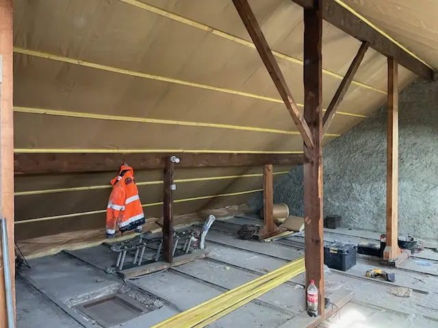 Isolation des combles sous toiture avec pare-vapeur et structure bois apparente, chantier de rénovation thermique en Île-de-France