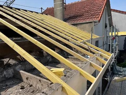 Réfection de charpente avec pose de chevrons et liteaux sur une toiture en rénovation, chantier de couverture en Île-de-France